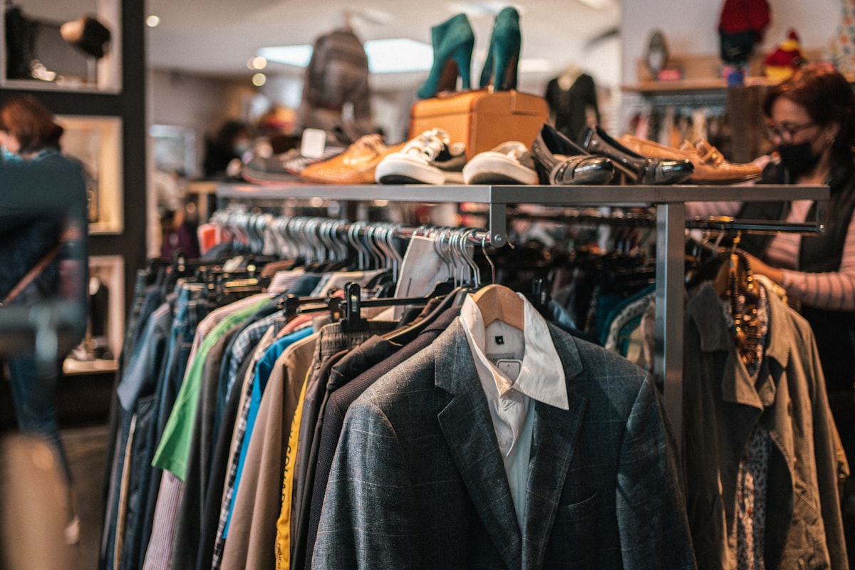 Rack of vintage blazers and shirts with shoes lined on top